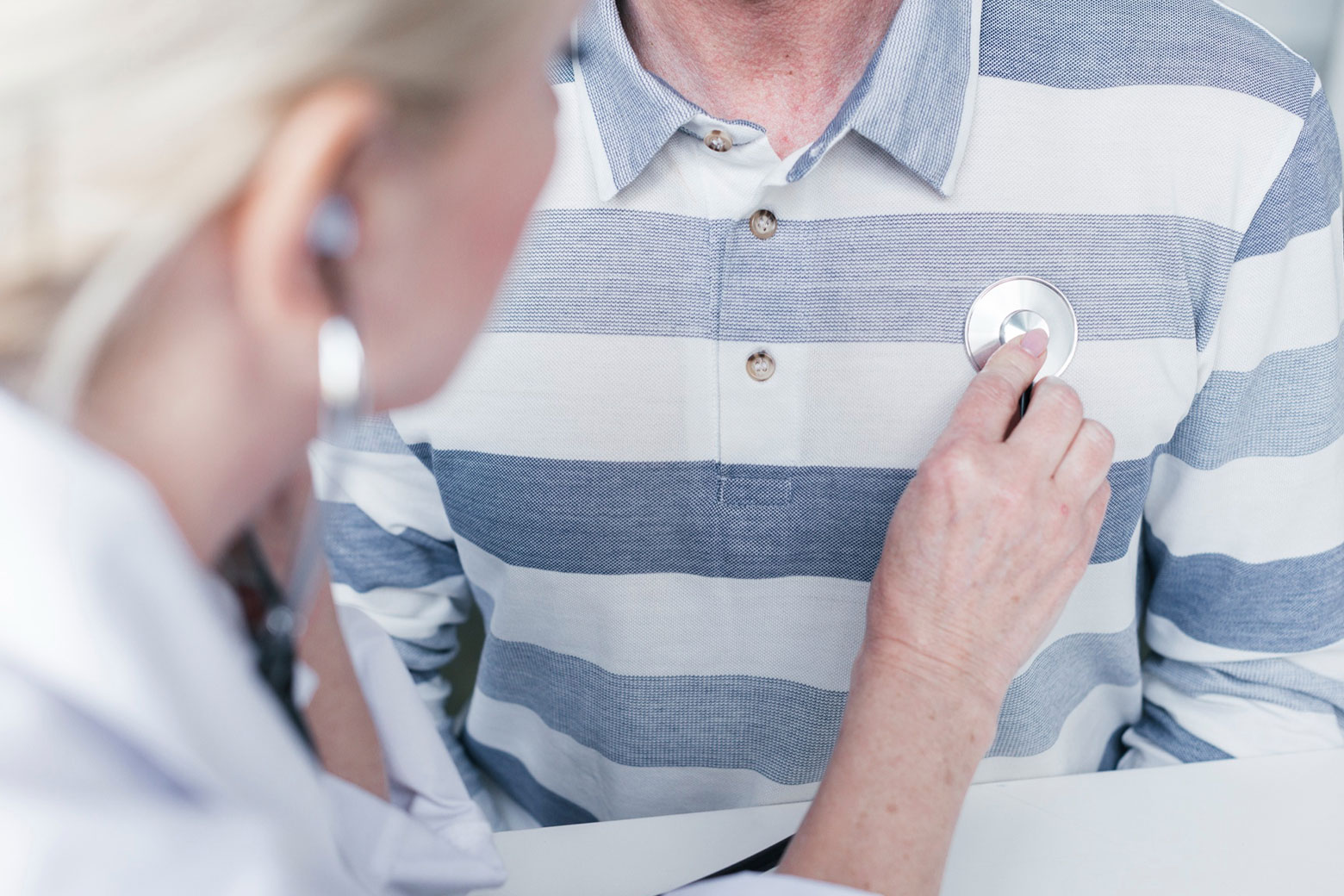 doctor listening to a patient's heart with a stethoscope